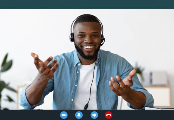 istock Web Conference. Happy Black Guy In Headset Making Video Call, Monitor Screenshot 1297634546