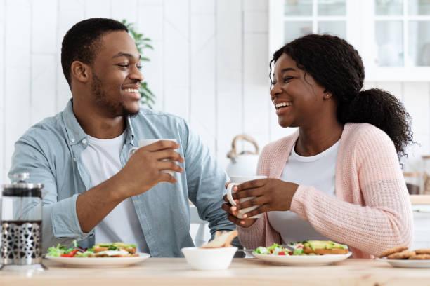 istock Cheerful African American Spouses Enjoying Their Breakfast And Drinking Coffee In Kitchen 1297635602