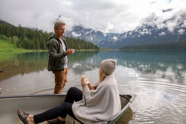 istock Couple share hot beverage in boat on alpine lake 1297635970