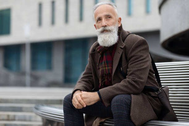 istock Pensive elderly man resting on bench after job 1297637116