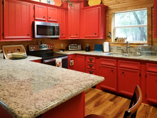 Kitchen in new home.  Red cabinets. Kitchen in a new home.  Gorgeous red cabinets with bold farmhouse hardware.  Granite counter tops. red kitchen cabinets stock pictures, royalty-free photos & images