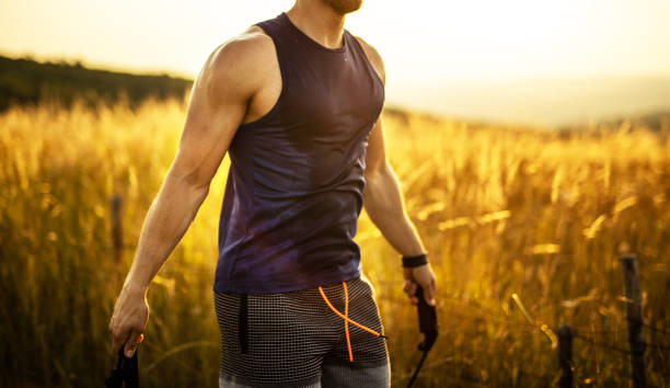 Man in sports clothing using jump rope while exercising in nature