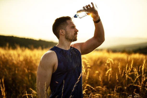 istock Athlete splashing water on his face after exercise in nature 1297638716