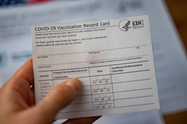 Close up view of blurred COVID-19 Vaccination Record Card by CDC in hand. stock photo