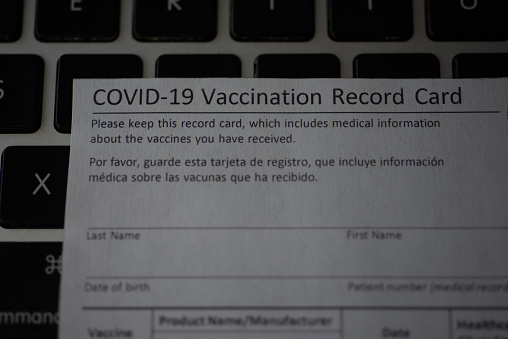 Washington, DC, USA - December, 23, 2020: Close up view of Blurred COVID-19 Vaccination Record card on keybord background.