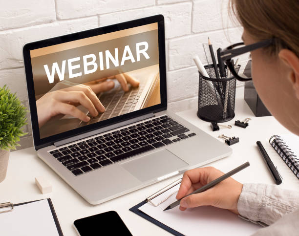 istock Young woman office worker taking notes while listening to webinar 1297642510