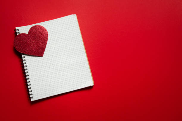 istock checkered notebook with valentine heart on red background 1297642643
