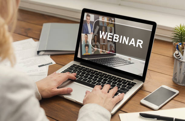 istock Unrecognizable woman typing on laptop with webinar inscription 1297642689