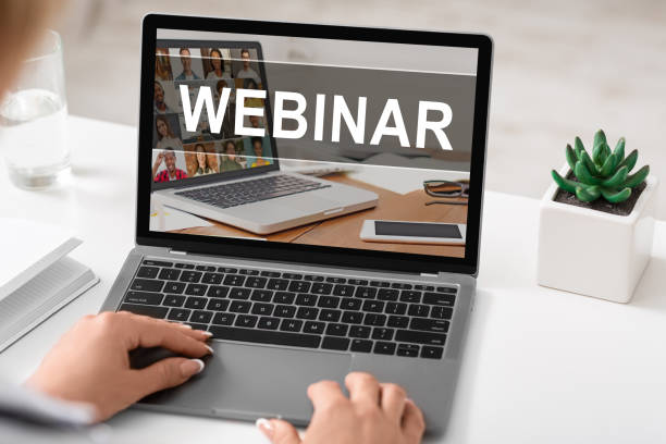 istock Female hands on laptop keyboard with webinar text on screen 1297642739