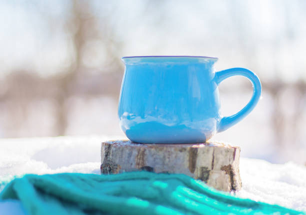 istock blue cup on a tree stump in a snowy forest 1297648082
