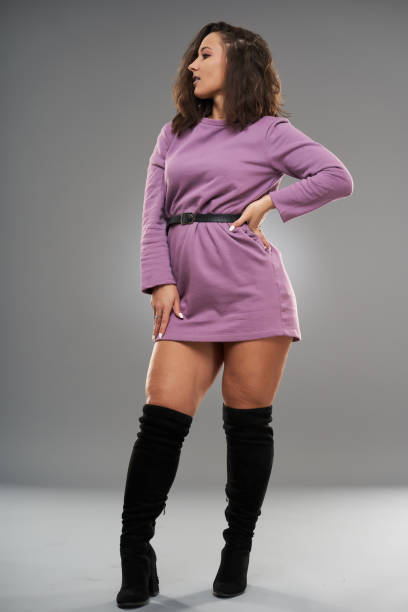 istock Beautiful plus size female model on gray 1297648149