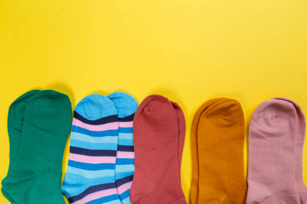 istock Multi-colored socks on a yellow background. View from above. Many different socks for cold seasons 1297649557