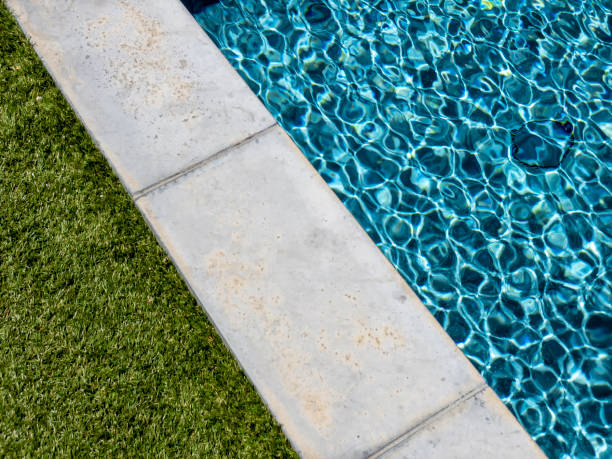 istock Poolside with green grass and vibrant color water 1297650113