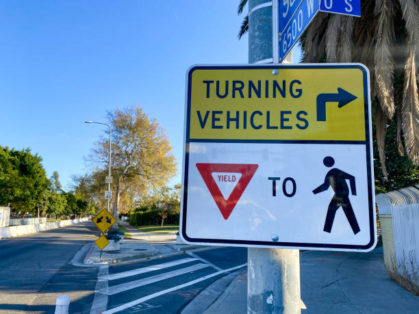 turning vehicles yield to pedestrian sign stock photo