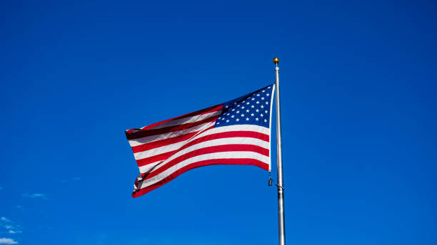 istock USA Flag waving in the blue sky 1297650790