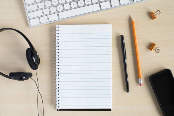 istock Flat lay on desk with computer keyboard, headphones, notepad and stationery. 1297651073