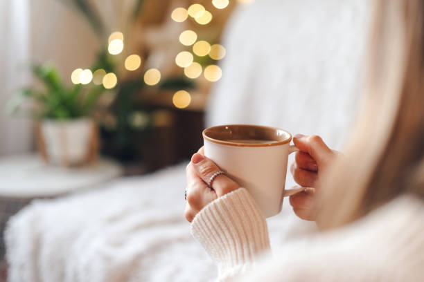 istock Woman's hands in sweater holding cup of coffee. 1297652173
