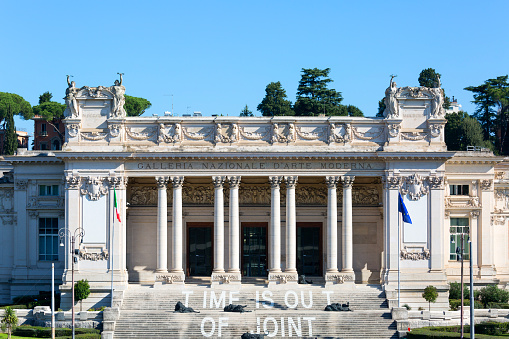 Rome, Italy - October 10, 2020: National Gallery of modern art next to Villa Borghese gardens, bronze Lions by Davide Rivalta on the stairs in front of the entrance. Gallery was founded in 1883 on dedicated to modern and contemporary art