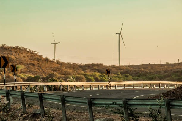 istock Closeup shot of windmills besides the road 1297653739