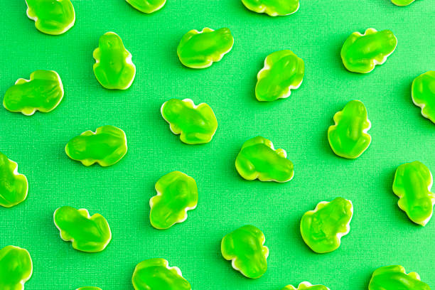 A Background of Gummy Green Frogs with a Mashmallow Candy Bottom Layer