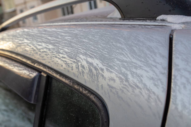 istock thin ice frost on silver car surface at morning - close-up with selective focus 1297654538