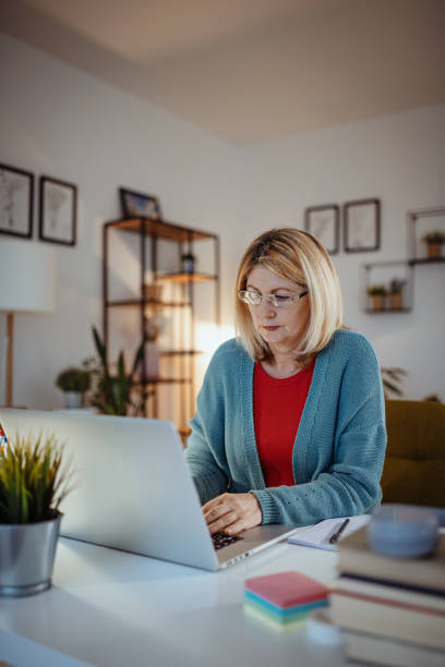 istock Retired woman working at home on laptop 1297654603