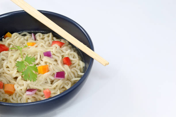 istock Noodles with vegetables in bowl isolated on white background 1297656001