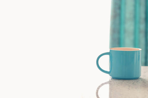 Close up blue cup on a white table on a White and Blue background