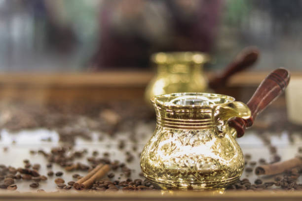 turc d’or sur une table en bois, grains de café dispersés et bâton de cannelle - fond de concept - coffee sack photos et images de collection