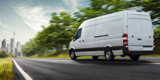 Delivery van delivers in a city Delivery van delivers in a city commercial land vehicle stock pictures, royalty-free photos & images