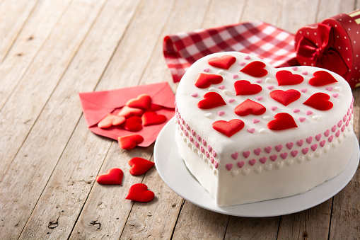 Heart cake for St. Valentine's Day, Mother's Day, or Birthday, decorated with sugar hearts on wooden table