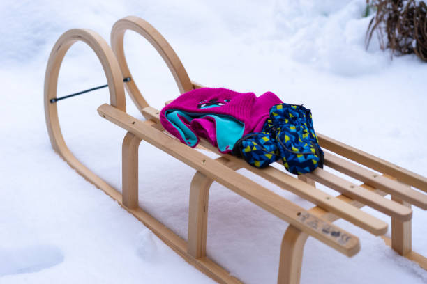 istock Wood sled set in the snow with winter accessories. 1297659915