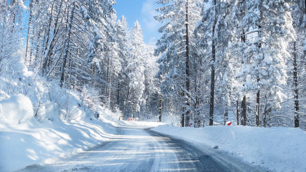 istock Snowy winter road in a mountain forest. 1297661705