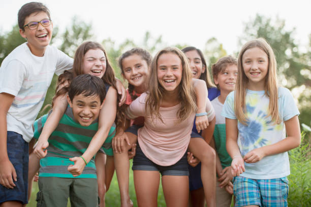 Portrait of multi ethnic teenagers A multi ethic group of teenagers are all huddled together for a photo. They are outdoors on a summer day. summer camp photos stock pictures, royalty-free photos & images