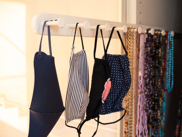 istock Four different anti-covid fabric face masks washable hanging in closet. 1297663975