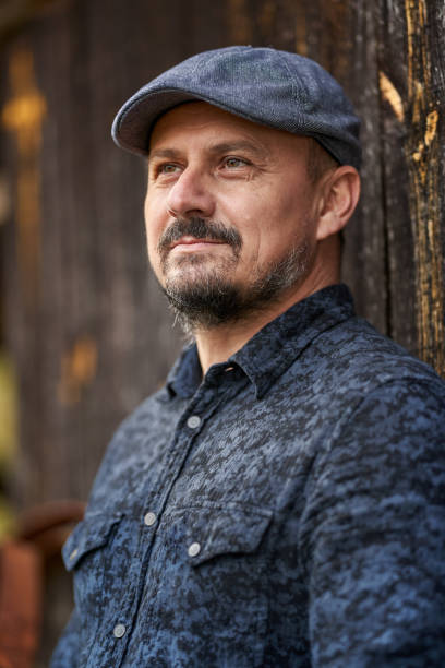 istock Farmer by a wooden wall of a barn 1297664903
