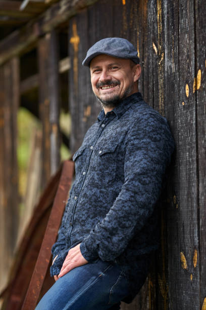 istock Farmer by a wooden wall of a barn 1297664911