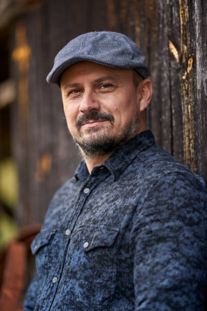 istock Farmer by a wooden wall of a barn 1297664915