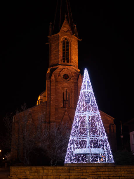 istock White lightning christmas tree outside in front of church. 1297667346