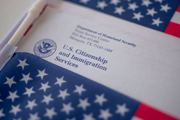 Letter (Envelope) from USCIS covered in flag of USA on American colors background. stock photo