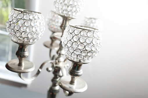 A white crystal chandelier hangs from the ceiling, close-up.