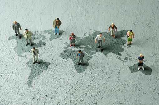 Businessperson/Politician figurines on world map. Global business communication concept.