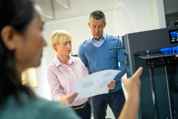 istock Colleagues standing in 3D printing office 1297671079