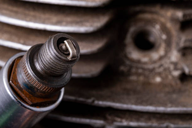 spark plug on the background of the internal combustion engine. minor repair work on the internal combustion engine. workshop workplace. - spark plug electrode transportation workshop imagens e fotografias de stock