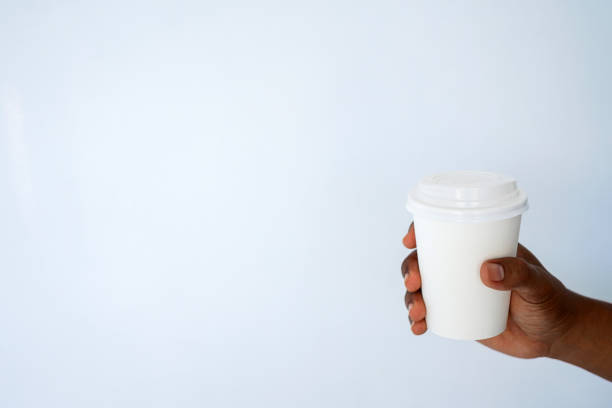 istock The hand of a dark-skinned man holds a disposable cup for coffee 1297671639