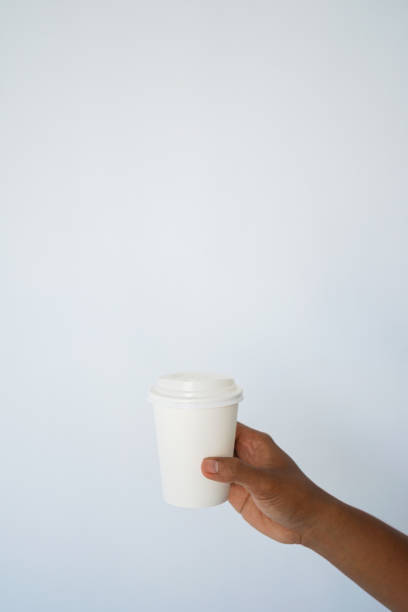 istock The hand of a dark-skinned man holds a disposable cup for coffee 1297671702