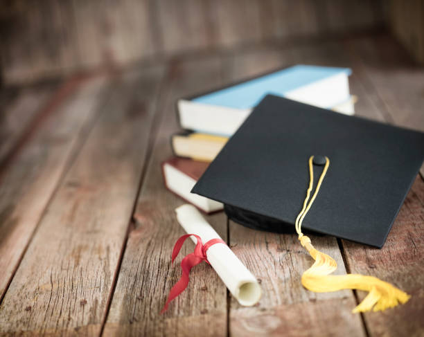 istock Graduation Cap and Diploma Concept on a Wood Background 1297672467