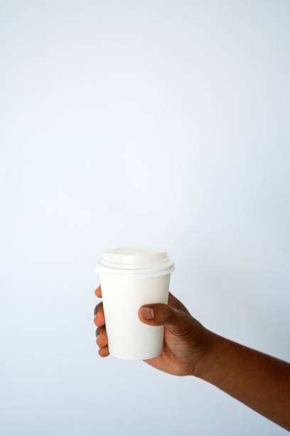 istock The hand of a dark-skinned man holds a disposable cup for coffee 1297672492