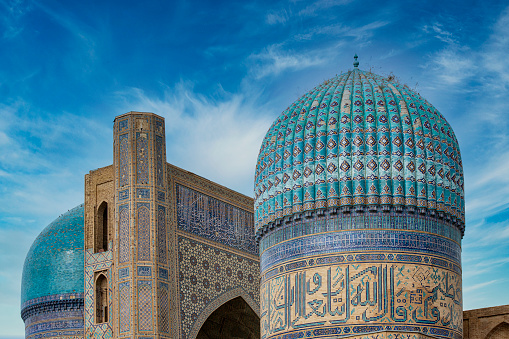 Two domes and an iwan (portal) of the Bibi-Khanym Mosque (also Bibi Yonum) in the city of Samarkand. The mosque was finished in 1404 and in the \n15th century it was one of the largest and most magnificent mosques in the Islamic world.\nSamarkand was one of the most important oasis and place of caravanserais at the Great Silk Road.