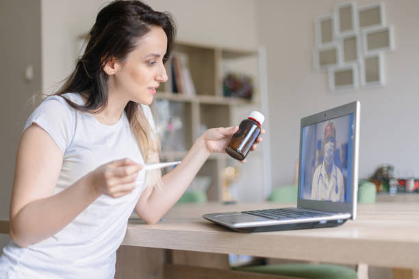istock Young woman using laptop and having video call with her doctor 1297672639